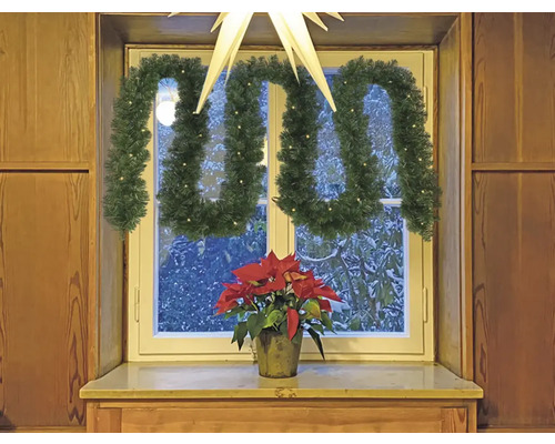 Décoration de fenêtre avec guirlande de sapin, étoile et poinsettia