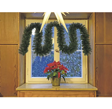 Rebord de fenêtre décoré avec une guirlande de sapin et une étoile de Noël