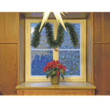 Vue de fenêtre décorée avec étoile de Noël, guirlande et poinsettia.