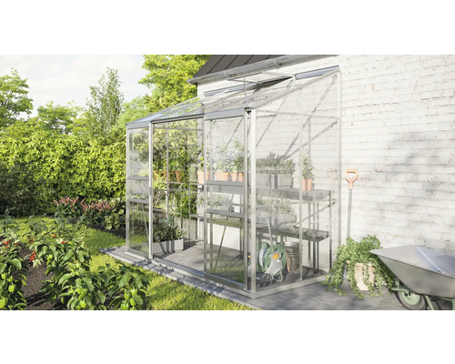 Gewächshaus mit Regalen und Gartengeräten im Garten