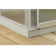 Vue détaillée d''une serre en métal et plastique sur une terrasse en bois