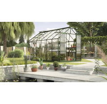 Gewächshaus im Garten mit Pflanzen, Blumen und Gartengeräten