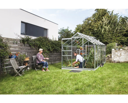 Serre de jardin avec deux femmes, l''une jardine, l''autre est assise.