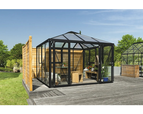 Serre avec parois en verre et intérieur en bois dans le jardin.