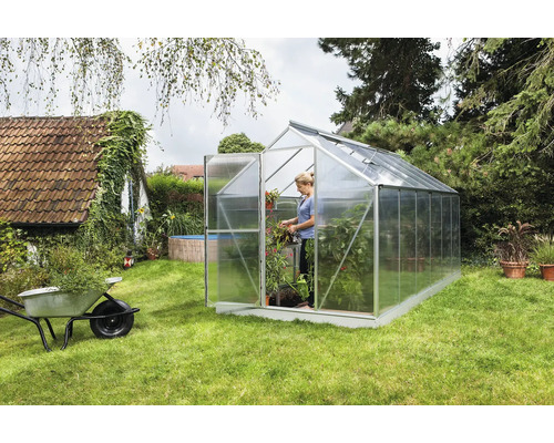 Serre dans le jardin avec femme et plantes