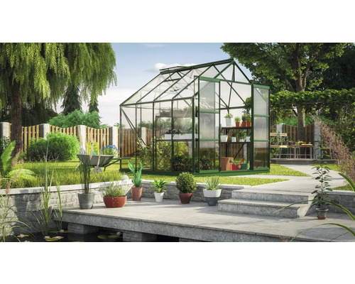 Serre dans le jardin avec plantes et outils de jardinage