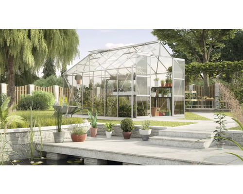 Gewächshaus im Garten mit Pflanzen und Gartengeräten