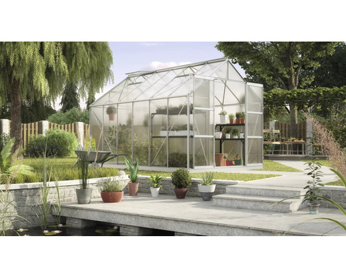 Gewächshaus im Garten mit Pflanzenregal und Gartenzubehör