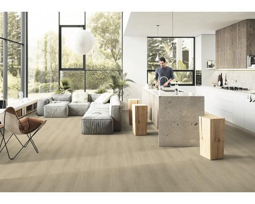 Heller, offener Wohnraum mit Holzboden, grauer Couch und Kücheninsel