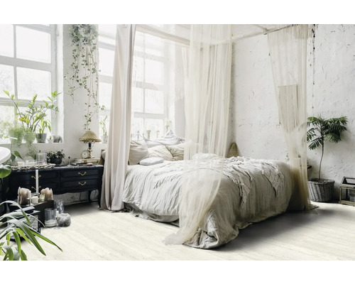 Helles Schlafzimmer mit Himmelbett, Pflanzen und Kommode