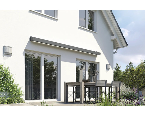 Hausfassade mit Markise über einer Terrassentür und einer Sitzgruppe