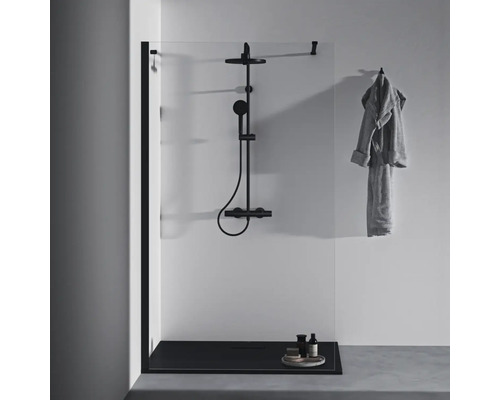 Duschkabine mit schwarzer Duscharmatur, Duschwanne und Handtuch