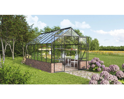 Serre avec mur en briques et parois en verre dans le jardin