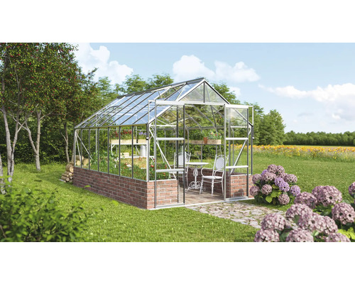 Serre avec étagères, table et chaises dans le jardin