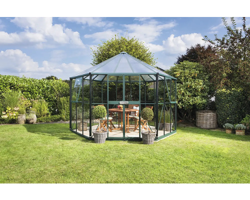 Pavillon de jardin octogonal en verre et métal dans le jardin avec table et chaises