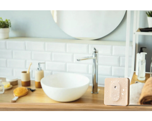 Modernes Badezimmer mit Waschbecken, Armatur und einem quadratischen, beigen Produkt auf einem Holztisch