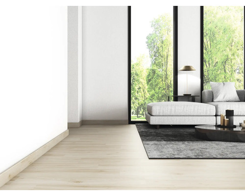 Heller Wohnraum mit Sofa, Teppich, Tisch und großem Fenster mit Blick ins Grüne.