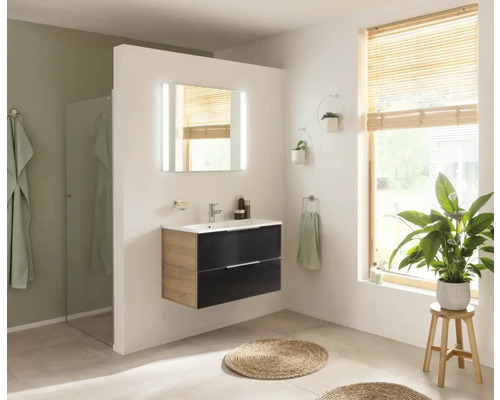 Salle de bain lumineuse avec meuble-lavabo, miroir avec éclairage et lumière naturelle.
