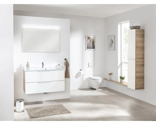Salle de bain lumineuse avec meuble-lavabo, miroir, toilettes et armoire haute.