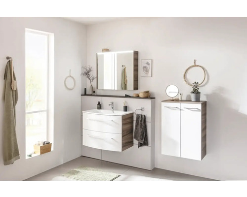 Salle de bains lumineuse avec meuble sous-lavabo, armoire de toilette, meuble suspendu et éléments décoratifs.