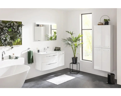 Salle de bains avec baignoire, meuble-lavabo, miroir, armoire haute et mur végétal