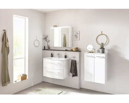 Salle de bain lumineuse avec lavabo, miroir, serviettes et décoration