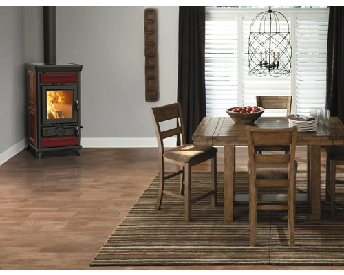 Esszimmer mit Kaminofen, Holztisch, Stühlen, Teppich und Pendelleuchte