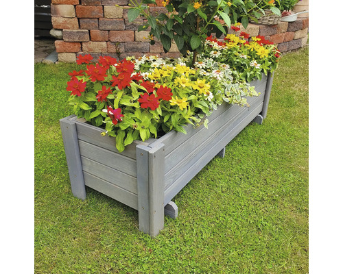 Jardinière en bois plantée de fleurs colorées sur une pelouse