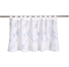 Brise-bise à pattes en tissu translucide avec motif floral bleu sur une tringle à rideau.
