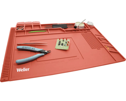 Tapis de soudure Weller avec outils et composants électroniques.