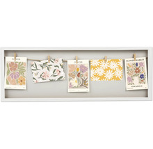 Dekorativer Bilderrahmen mit floralen Motiven an einer Schnur befestigt