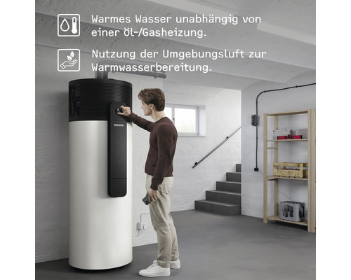 Mann bedient eine Warmwasser-Wärmepumpe in einem Kellerraum