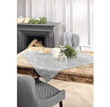 Table de salle à manger décorative avec chemin de table, table mise et cheminée en arrière-plan.