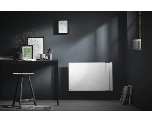 Modern eingerichteter Raum mit Elektroheizung an der Wand, Schreibtisch, Hocker und dekorativen Elementen.