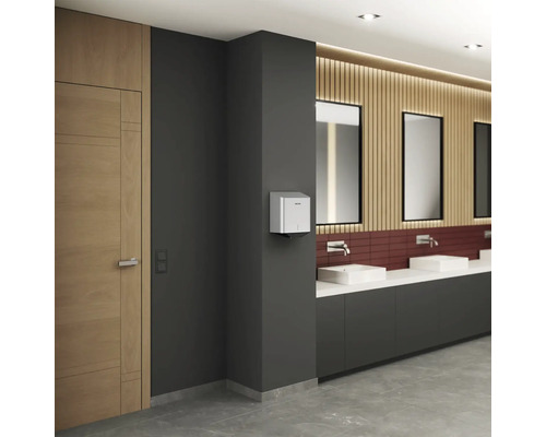 Innenaufnahme eines Waschraums mit Papierhandtuchspender, Waschbecken und Spiegeln