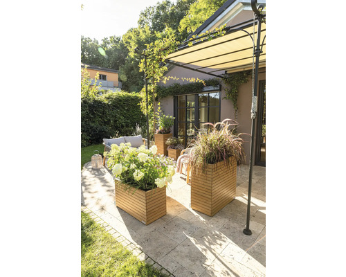 Terrasse avec salon de jardin, bacs à fleurs en bois et store extérieur.