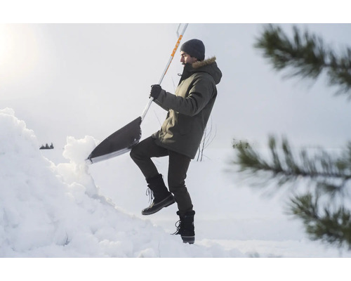 Un homme déblaie la neige avec une pelle à neige.