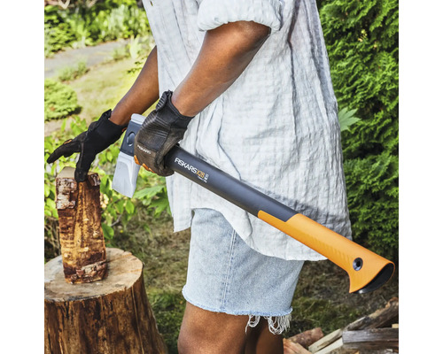 Personne fendant du bois avec une hache à fendre Fiskars X28