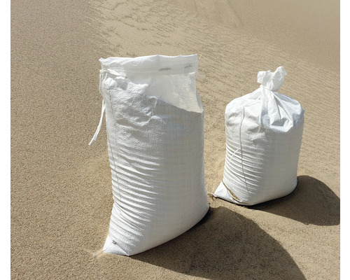 Deux sacs de sable en plastique sur un sol sablonneux