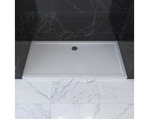 Rechteckige Duschwanne mit Ablauf in einem Badezimmer mit Marmorfliesen