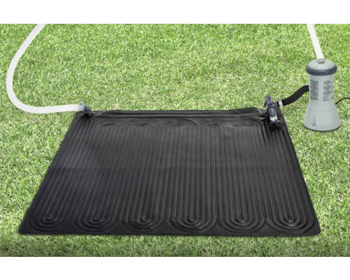 Tapis solaire de chauffage pour piscines sur une pelouse, relié à une pompe de filtration.