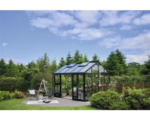 Gewächshaus im Garten mit Sitzbereich und bepflanzten Regalen