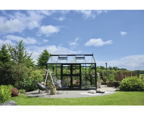 Gewächshaus im Garten mit Pflanzen und Gartenmöbeln