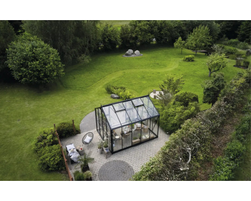 Übersicht eines Gartens mit Gewächshaus und Sitzecke