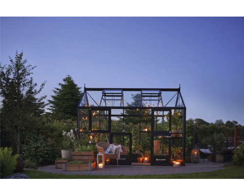 Gewächshaus mit Pflanzen, Sitzgelegenheiten und Beleuchtung im Garten.