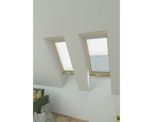 Zwei Dachfenster mit Verdunkelungsrollos in einem hellen Raum.