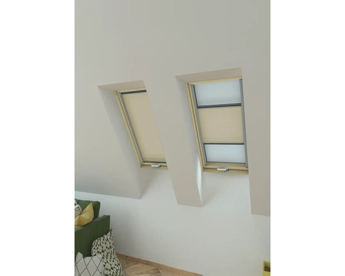 Deux fenêtres de toit avec stores occultant dans une pièce lumineuse.