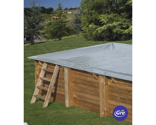 Piscine en bois avec couverture et échelle dans le jardin. Logo Gre.