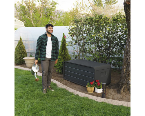 Szene im Garten mit einer Aufbewahrungsbox, einem Mann mit einer Gießkanne und Topfpflanzen