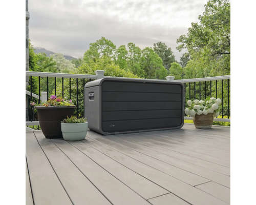 Aufnahme einer grauen Gartenbox auf einer Terrasse neben Blumentöpfen.